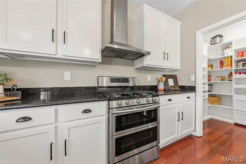 Granite countertops, stainless steel vent over gas range & double-oven — 106 Crimson Oaks Court, Lake St. Louis, MO 63367