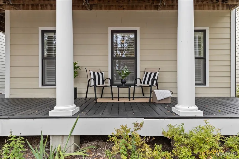 Covered porch featuring dark wood-finish decking, structural columns, and horizontal lap siding — 3222 Starkville Street, St Charles, MO 63301
