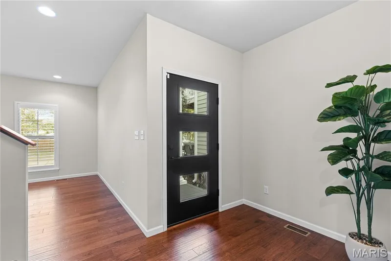 Entryway featuring wood-finish flooring, a matte black exterior door with three rectangular glass inserts, and recessed ceiling lighting — 3222 Starkville Street, St Charles, MO 63301