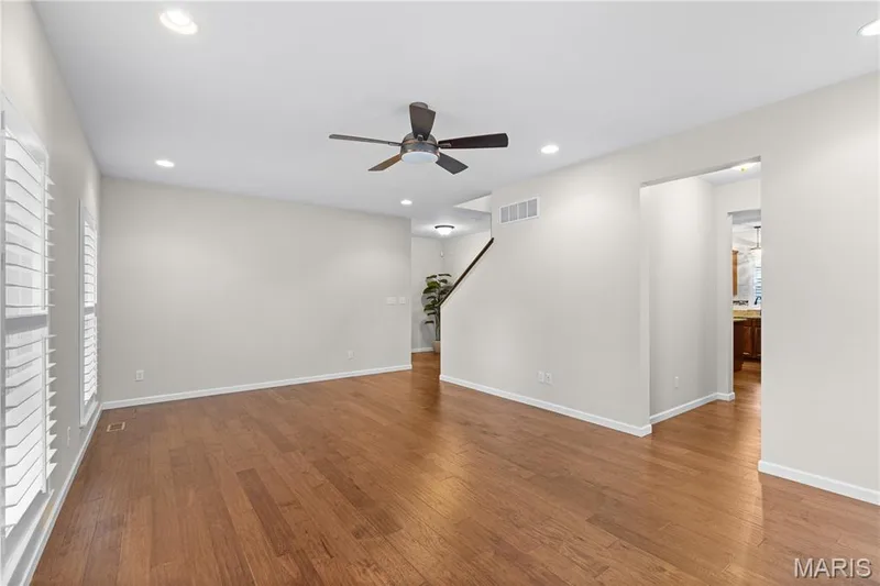 Interior space featuring wood-finish flooring, recessed lighting, ceiling fan, and white shutters — 3222 Starkville Street, St Charles, MO 63301