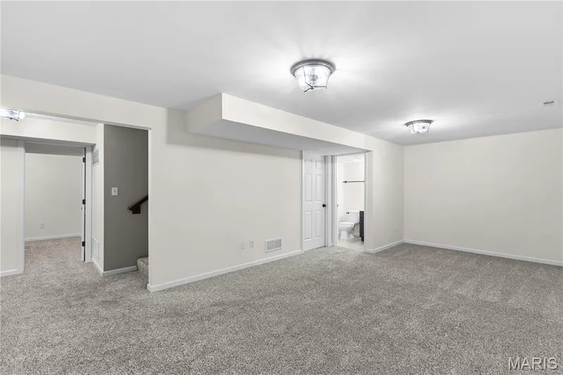Interior space featuring neutral wall-to-wall carpeting, dual flush-mount ceiling light fixtures, and multi-panel interior doors — 3222 Starkville Street, St Charles, MO 63301
