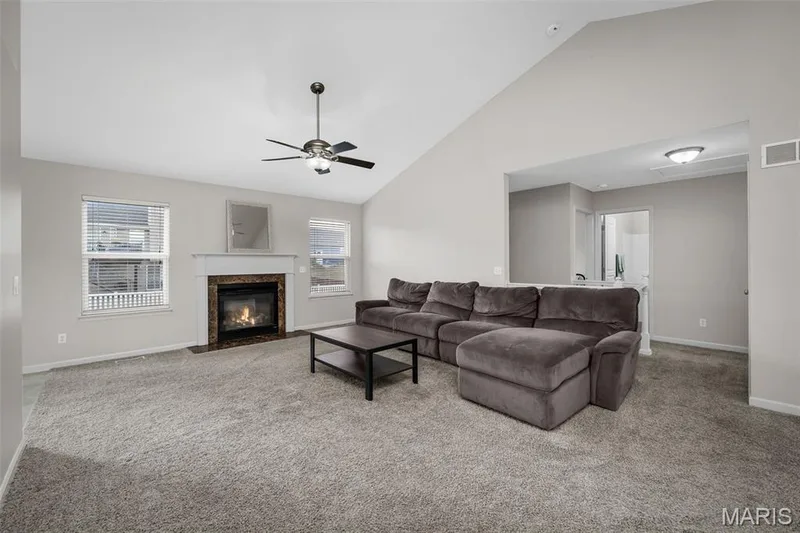 Vaulted ceilings, fireplace with a tile surround and mantel, and ceiling fan fixture — 757 Lost Canyon Boulevard, Wentzville, MO 63385