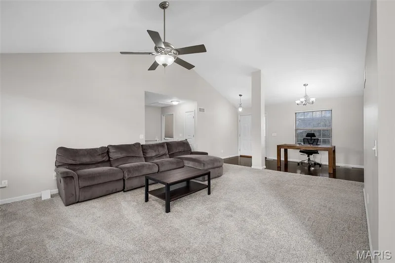 Vaulted ceilings, neutral carpeting, brushed nickel ceiling fan with integrated lighting, multi-arm chandelier, and carpeted flooring — 757 Lost Canyon Boulevard, Wentzville, MO 63385