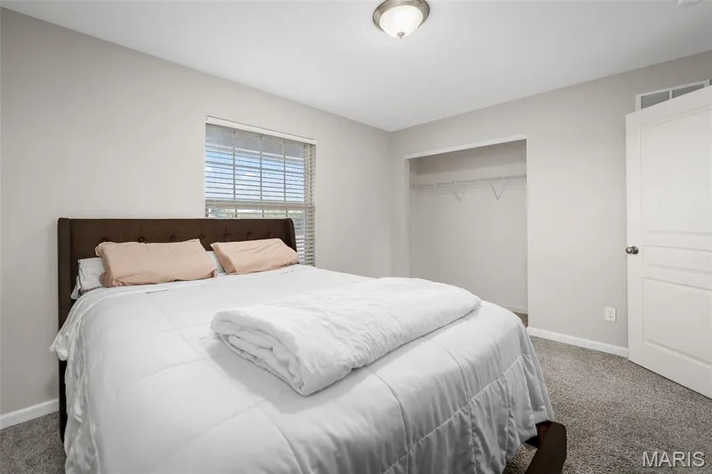 Neutral-toned walls, wall-to-wall carpeting, window with blinds, reach-in closet with built-in shelving, and flush-mount ceiling lighting — 757 Lost Canyon Boulevard, Wentzville, MO 63385