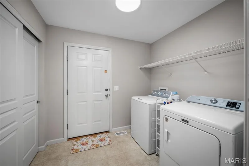 Laundry room featuring a paneled door, neutral wall paint, overhead lighting, and wall-mounted wire shelving — 757 Lost Canyon Boulevard, Wentzville, MO 63385