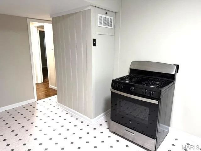 Stainless steel gas range with black glass finish and vertical plank wall detailing — 529 Emmons Avenue, St Charles, MO 63301