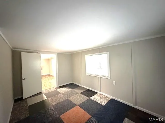 Neutral-toned walls with panel detailing, modular carpet tile flooring, and a single-hung window — 529 Emmons Avenue, St Charles, MO 63301