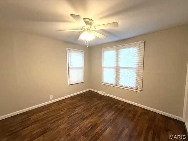 Room featuring wood-finish flooring, a ceiling fan with integrated lighting, and dual windows equipped with horizontal blinds — 529 Emmons Avenue, St Charles, MO 63301
