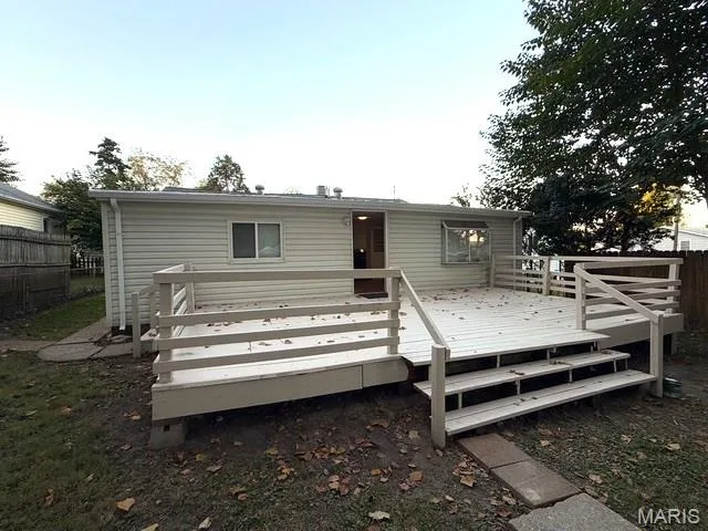 Spacious elevated wood deck featuring horizontal railings and integrated stair access, complemented by light-toned horizontal siding — 529 Emmons Avenue, St Charles, MO 63301
