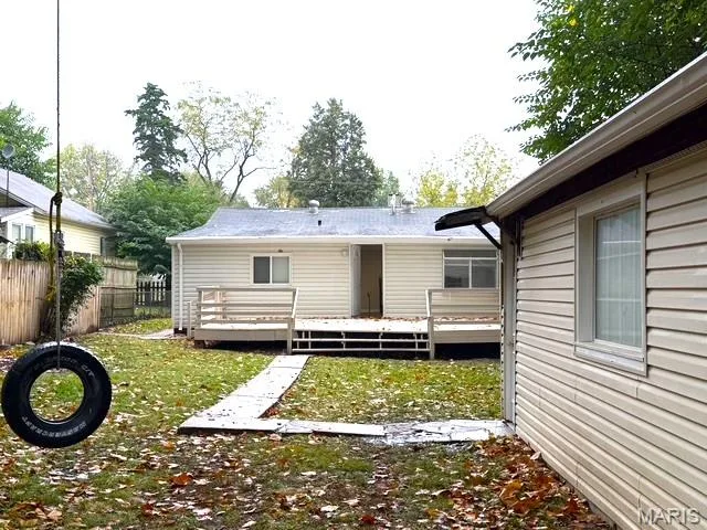 Rear exterior featuring vinyl siding, an elevated wood deck, and a concrete paver walkway — 529 Emmons Avenue, St Charles, MO 63301