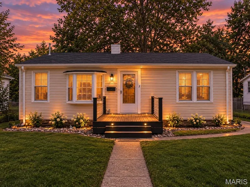 Single-story residence featuring horizontal siding, a bay window, a raised deck with metal railing, and a stone-bordered garden bed — 529 Emmons Avenue, St Charles, MO 63301