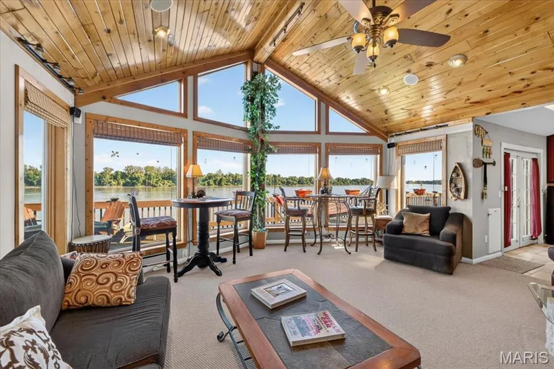 Vaulted tongue-and-groove wood plank ceiling, expansive floor-to-ceiling windows, and integrated ceiling fan with light fixture — 69 Weule Boat Harbor, St Charles, MO 63301