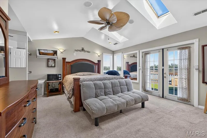 Vaulted ceilings featuring skylights, a multi-blade ceiling fan, and dual glass-panel French doors — 69 Weule Boat Harbor, St Charles, MO 63301