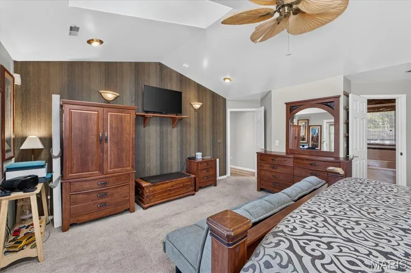 Vaulted ceilings, vertical wood-finish accent wall, recessed lighting, and ceiling fan with palm-style blades — 69 Weule Boat Harbor, St Charles, MO 63301