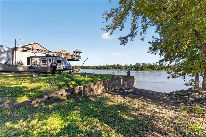 Waterfront parcel featuring a concrete boat ramp, stone retaining wall, and mature trees — 69 Weule Boat Harbor, St Charles, MO 63301