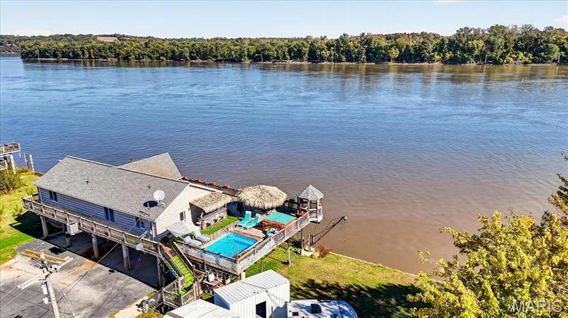 Elevated structure featuring a waterfront deck, integrated swimming pool, attached gazebo, and bulkhead — 69 Weule Boat Harbor, St Charles, MO 63301