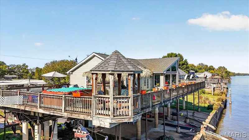 Elevated wraparound deck featuring an integrated gazebo, built-in hot tub, and direct water frontage — 69 Weule Boat Harbor, St Charles, MO 63301