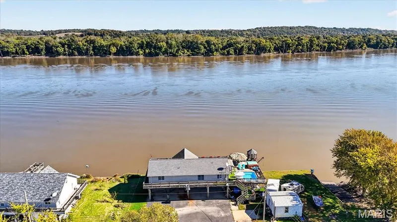 Waterfront property featuring a raised exterior deck, in-ground pool, and direct river access — 69 Weule Boat Harbor, St Charles, MO 63301