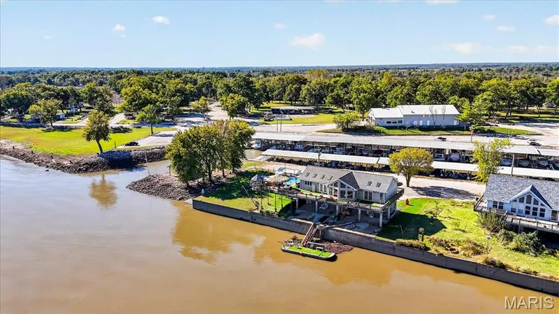 Waterfront property featuring a private boat dock, stone retaining wall, expansive elevated deck, and skylights — 69 Weule Boat Harbor, St Charles, MO 63301