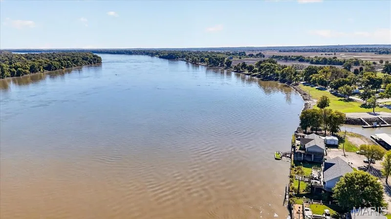 Aerial perspective featuring expansive river frontage, private boat docks, and direct shoreline access — 69 Weule Boat Harbor, St Charles, MO 63301