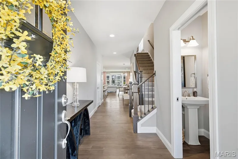 Entryway featuring wood-finish flooring, recessed lighting, and a staircase with wood-capped railings and metal balusters — 17028 Fire Glow Drive, Wildwood, MO 63011