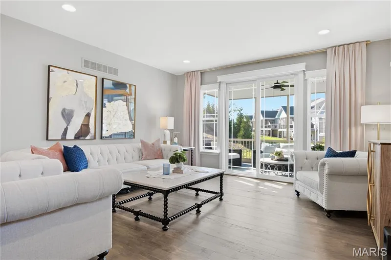 Living space featuring wood-finish flooring, recessed lighting, and large sliding glass doors providing outdoor access — 17028 Fire Glow Drive, Wildwood, MO 63011