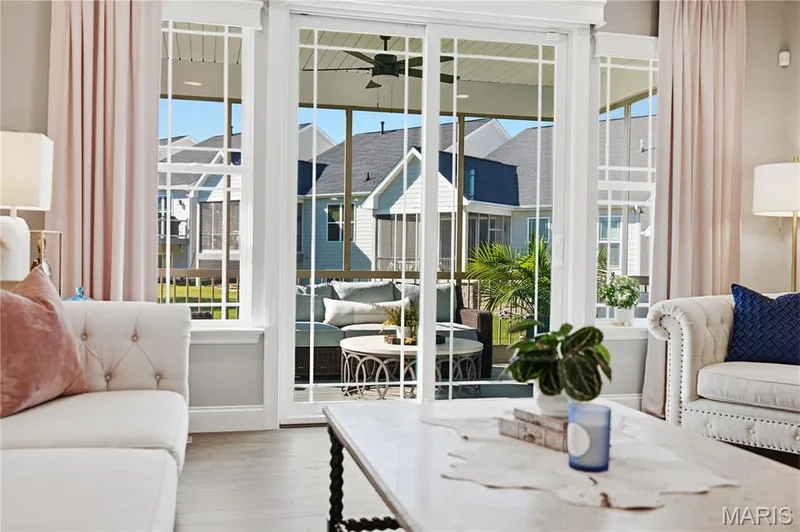 Sliding glass door with white grid mullions, wood-finish flooring, and a covered screen enclosure — 17028 Fire Glow Drive, Wildwood, MO 63011