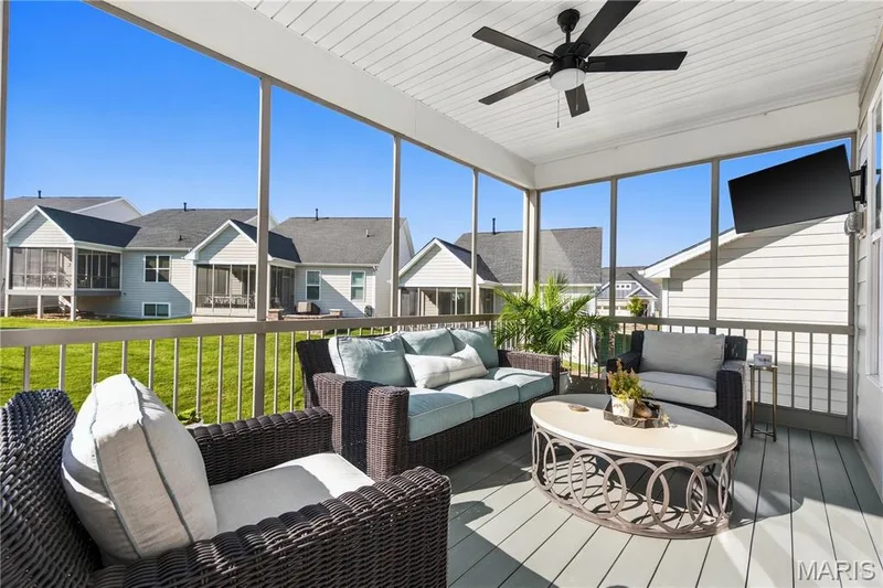 Screened porch featuring composite decking, white beadboard ceiling, integrated ceiling fan, and metal railings — 17028 Fire Glow Drive, Wildwood, MO 63011