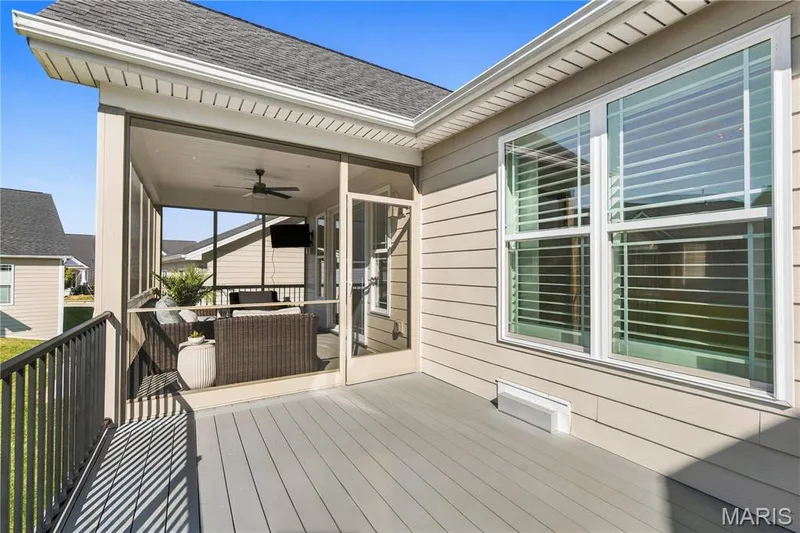 Covered screened-in porch with ceiling fan and composite decking, featuring horizontal lap siding and multi-pane windows — 17028 Fire Glow Drive, Wildwood, MO 63011