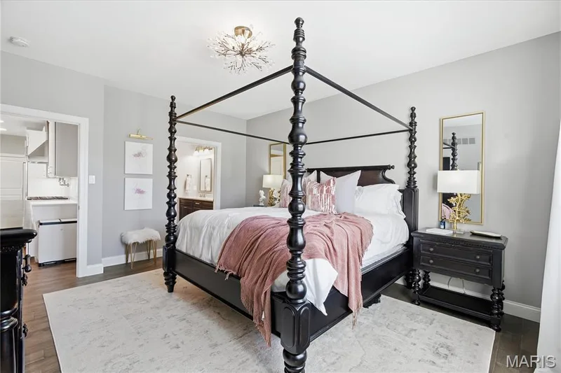 Neutral-toned room featuring wood-finish flooring and a central starburst-style overhead light fixture — 17028 Fire Glow Drive, Wildwood, MO 63011