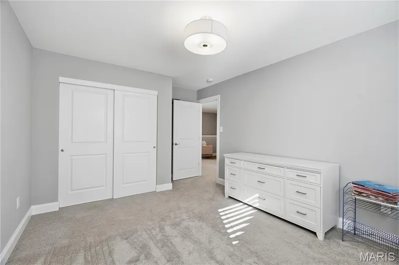 Neutral-toned wall paint, wall-to-wall carpeting, drum-style ceiling light fixture, and a sliding-door closet — 17028 Fire Glow Drive, Wildwood, MO 63011