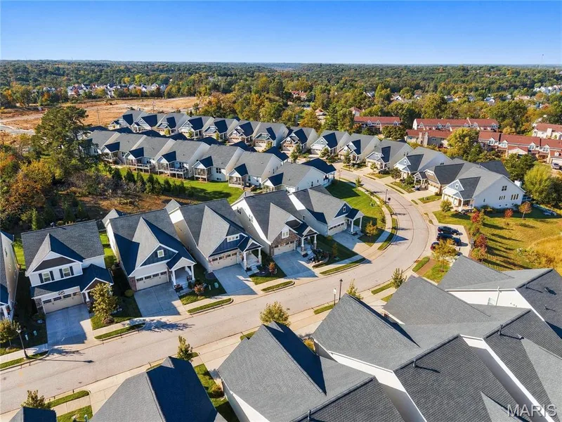 Aerial perspective of a planned community featuring multi-gabled rooflines, attached garages, and concrete driveways — 17028 Fire Glow Drive, Wildwood, MO 63011