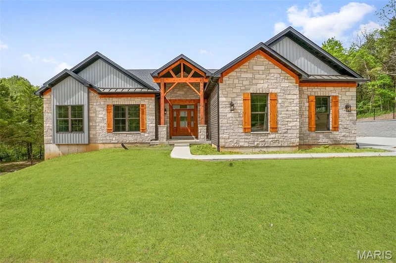 Optional Upgrade Elevation with Stone front, cedar shutters and metal shed style overhangs. Photo of Previously Built Home — Sycamore-Ests @ Schaper Farms, Foristell, MO 63348