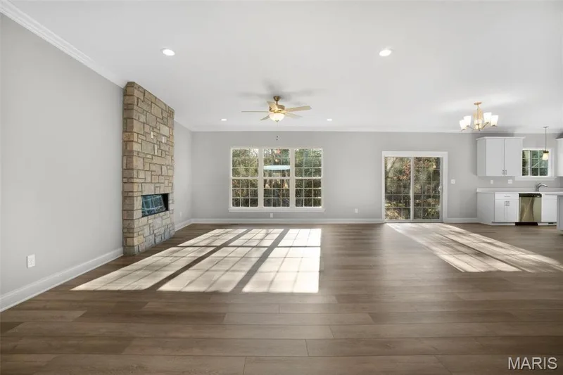 Great Room with triple window and optional electric fireplace with floor to ceiling stone. Double slider off dining area. (Photo of previously built Sycamore - upgrades may be shown) — Sycamore-Ests @ Schaper Farms, Foristell, MO 63348