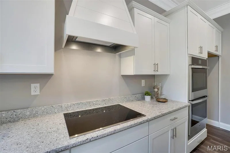 Optional upgrade with hood to match cabinets, smooth cooktop and built in double oven. (Photo of previously built Sycamore - upgrades may be shown) — Sycamore-Ests @ Schaper Farms, Foristell, MO 63348
