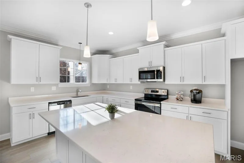 Standard kitchen shown with Quartz countertops, staggered cabinets, and stainless GE appliances. (Photo of previously built Sycamore - upgrades may be shown) — Sycamore-Ests @ Schaper Farms, Foristell, MO 63348