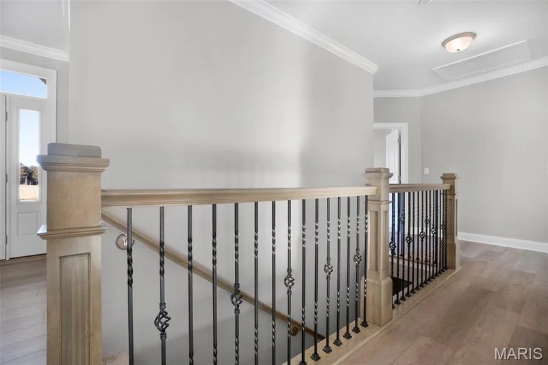 Newel posts with wrought iron spindles. (Photo of previously built Sycamore - upgrades may be shown) — Sycamore-Ests @ Schaper Farms, Foristell, MO 63348