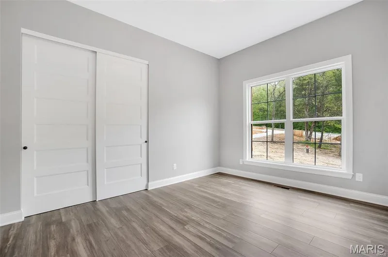 Bedroom 2 with LVP Flooring, double window and slatted doors. (Photo of previously built Sycamore - upgrades may be shown) — Sycamore-Ests @ Schaper Farms, Foristell, MO 63348