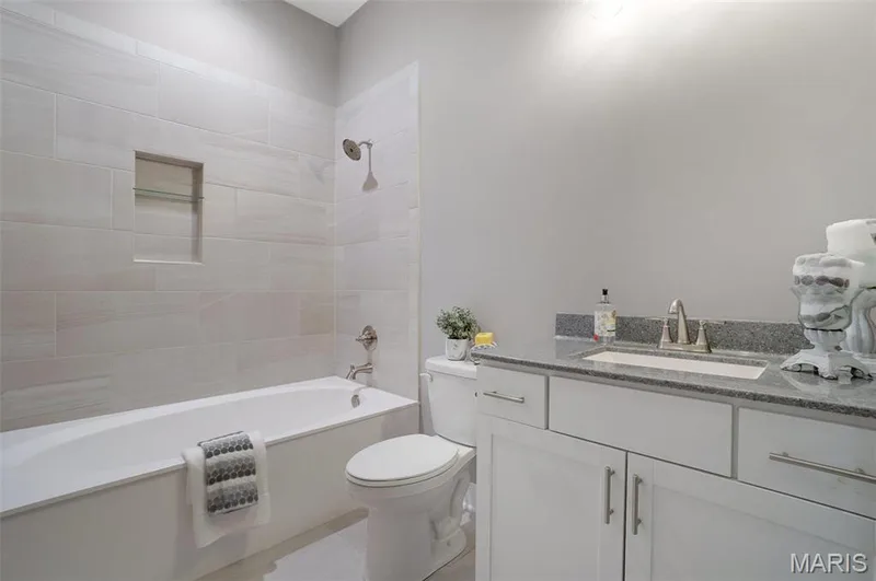 Hall bath with oval marble soaking tub and tiled walls. (Photo of previously built Sycamore - upgrades may be shown) — Sycamore-Ests @ Schaper Farms, Foristell, MO 63348
