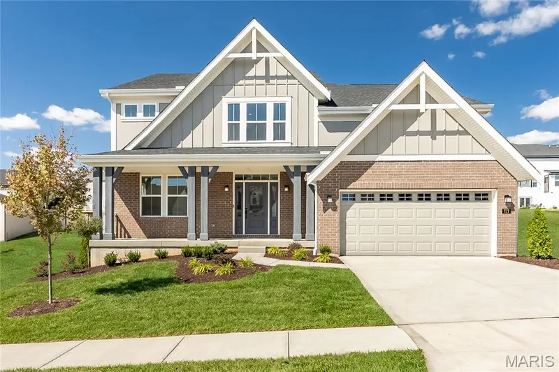 Craftsman-style home with board and batten siding, a porch, a front yard, and driveway — 717 Southerland Drive, O'Fallon, MO 63368