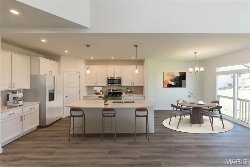 Kitchen featuring appliances with stainless steel finishes, white cabinetry, dark wood-style flooring, recessed lighting, and a center island with sink — 717 Southerland Drive, O'Fallon, MO 63368
