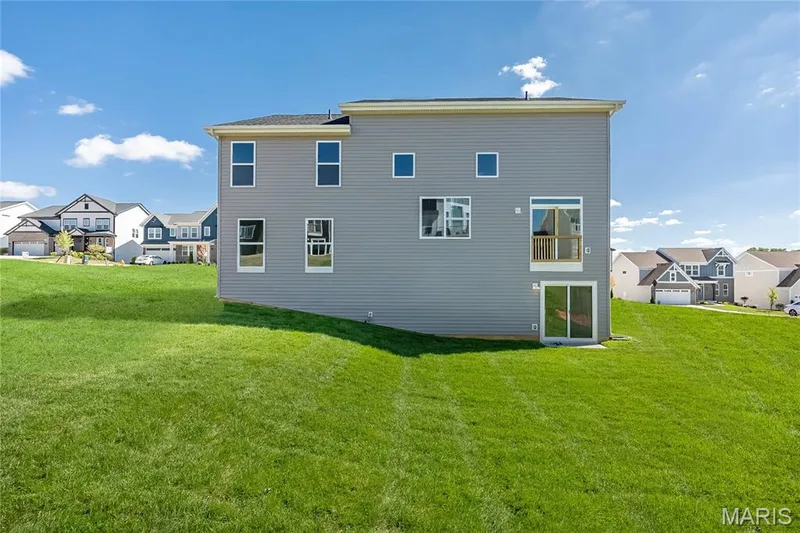Back of house with a residential view and a yard — 717 Southerland Drive, O'Fallon, MO 63368