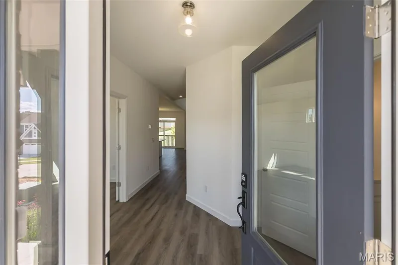 Hallway featuring dark wood-style flooring and baseboards — 717 Southerland Drive, O'Fallon, MO 63368