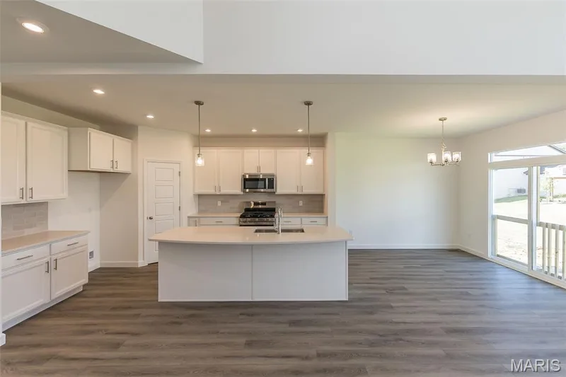 Kitchen featuring tasteful backsplash, dark wood-style flooring, white cabinets, stainless steel appliances, and recessed lighting — 717 Southerland Drive, O'Fallon, MO 63368