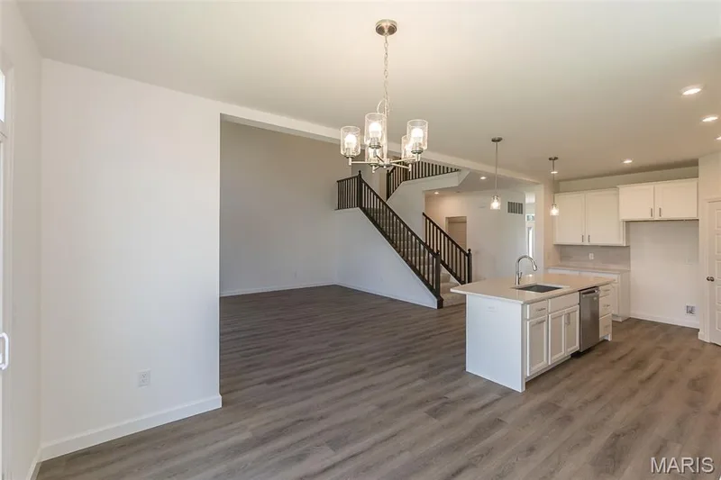 Kitchen featuring decorative light fixtures, white cabinetry, a chandelier, a kitchen island with sink, and recessed lighting — 717 Southerland Drive, O'Fallon, MO 63368