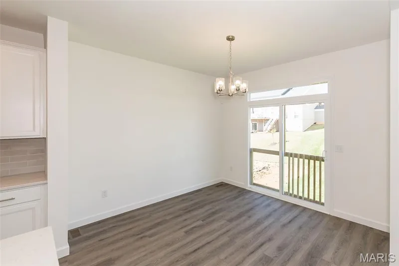 Unfurnished dining area with dark wood-style floors and a chandelier — 717 Southerland Drive, O'Fallon, MO 63368