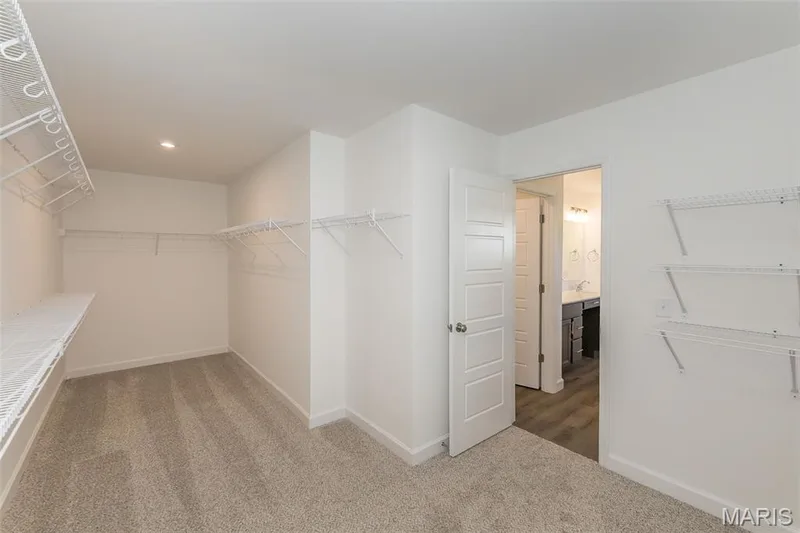Walk in closet featuring light carpet — 717 Southerland Drive, O'Fallon, MO 63368