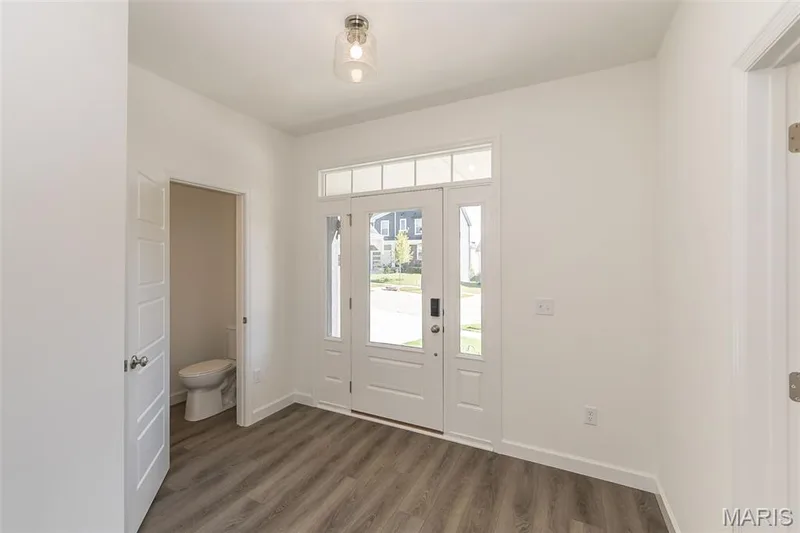 Foyer featuring dark wood finished floors and baseboards — 717 Southerland Drive, O'Fallon, MO 63368