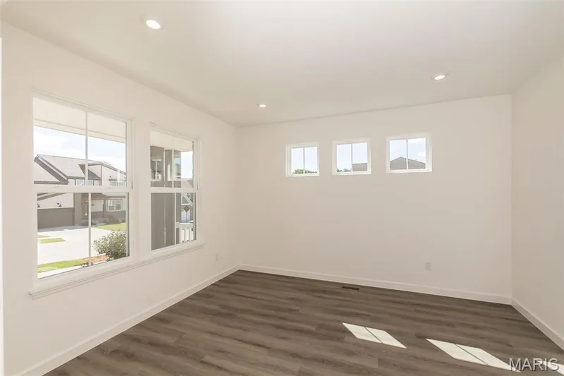 Spare room featuring dark wood-style floors and recessed lighting — 717 Southerland Drive, O'Fallon, MO 63368