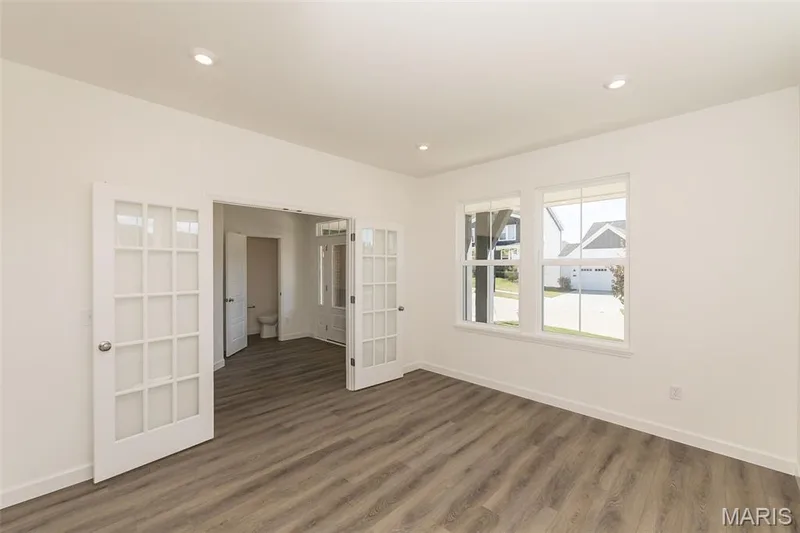 Unfurnished bedroom with french doors and dark wood-style flooring — 717 Southerland Drive, O'Fallon, MO 63368